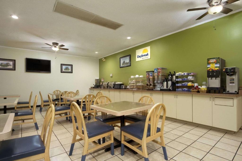 un restaurante con mesas, sillas y una barra en Days Inn by Wyndham Hardeeville/ I-95 State Line, en Hardeeville