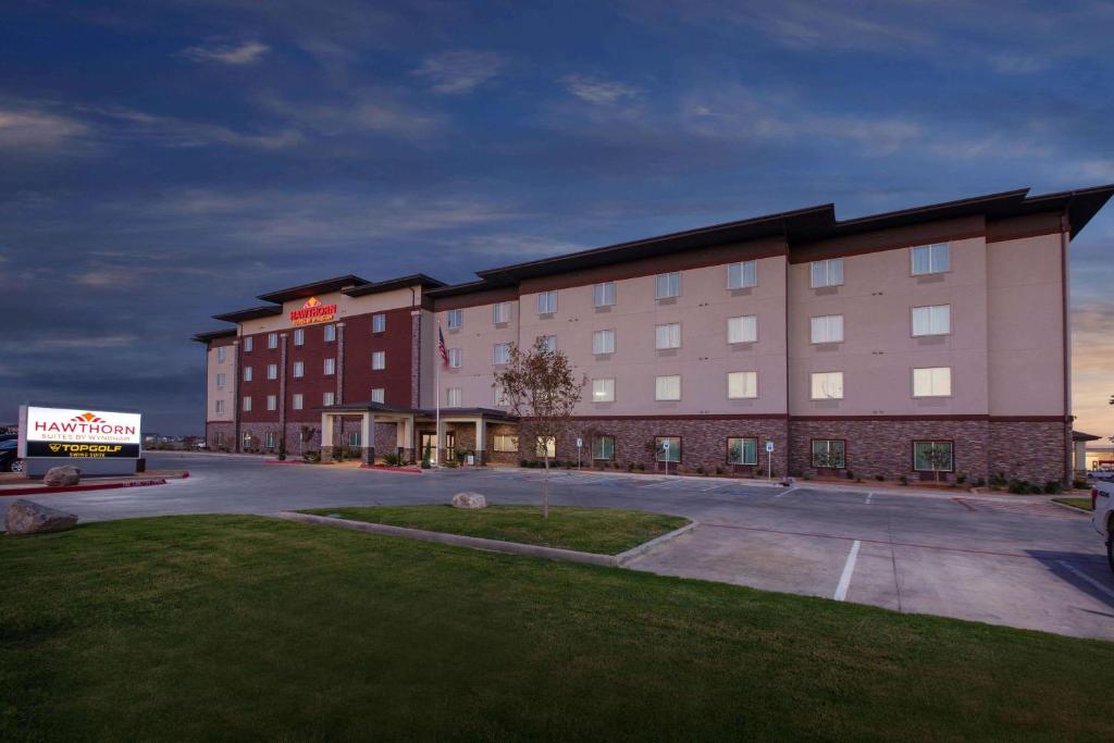 a large hotel with a parking lot in front of it at Hawthorn Suites By Wyndham Odessa in Odessa