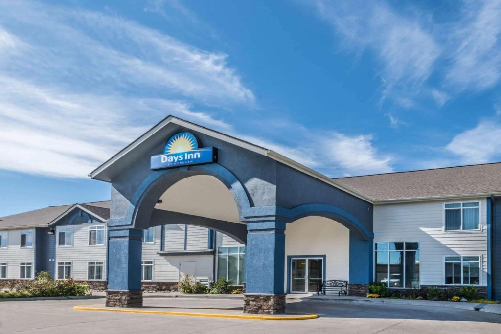 a building with a sign for a hotel at Days Inn by Wyndham Great Falls in Great Falls