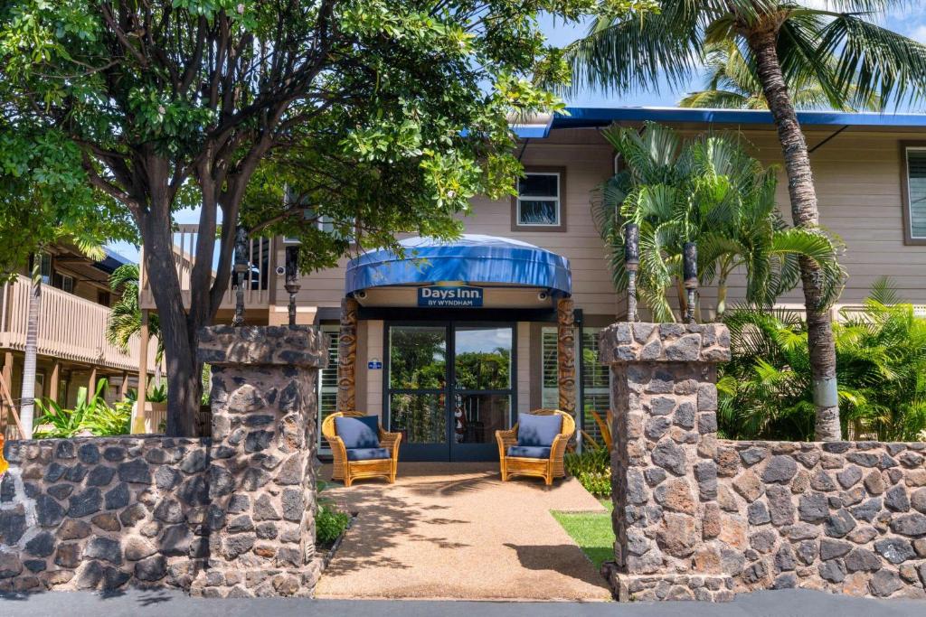 a bus is parked in front of a stone building at Days Inn by Wyndham Maui Oceanfront in Wailea