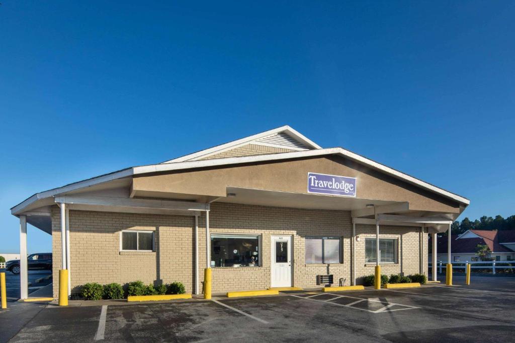 a front view of a building with a pharmacy at Travelodge by Wyndham Orangeburg in Orangeburg