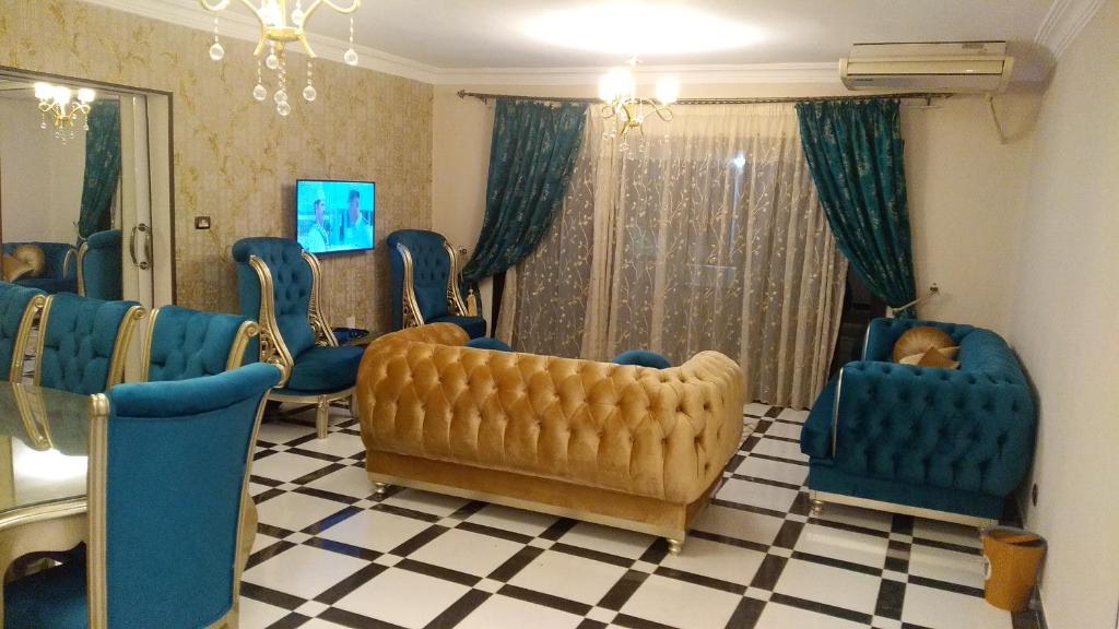 uma sala de espera com cadeiras azuis e um espelho em شقة مكرم عبيد للعائلات فقط 21 no Cairo