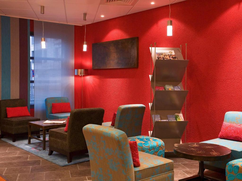 a waiting room with chairs and red walls at Novotel Suites Nancy Centre in Nancy