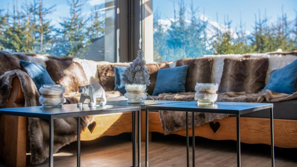 two tables in a living room with a couch at Hôtel Arbois Bettex in Saint-Gervais-les-Bains