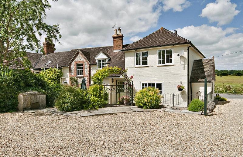 een wit huis met een poort op een oprit bij Cleaver Cottage in Andover