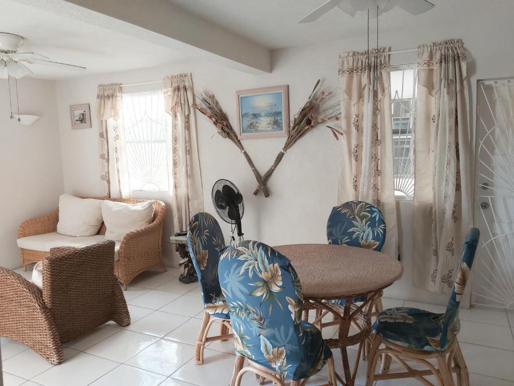 uma sala de estar com mesa e cadeiras em Clearwater Apartments em Christ Church