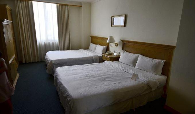 Postel nebo postele na pokoji v ubytování Cambridge Hotel - Yung Kang