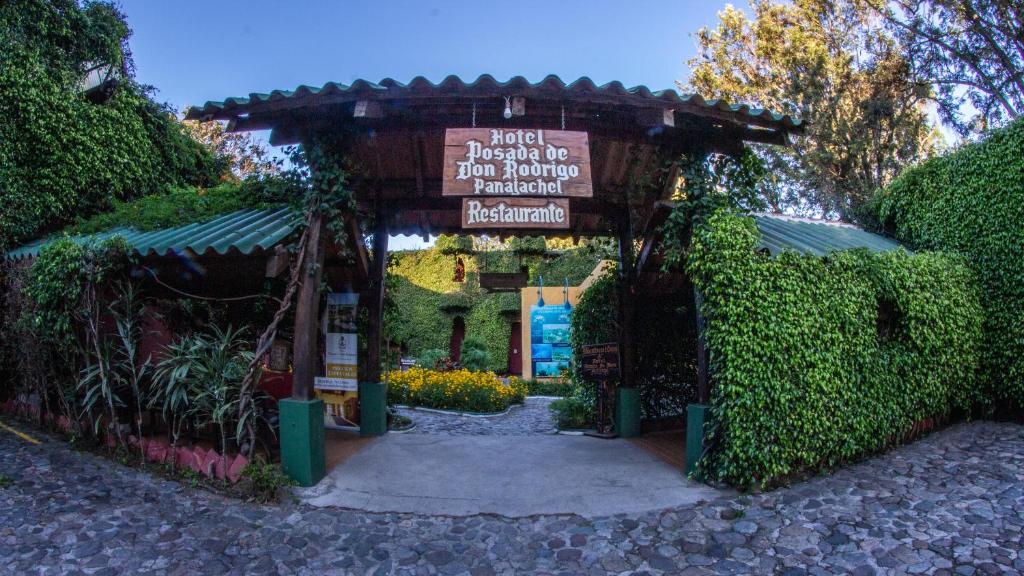 einen Zugang zu einem Garten mit einem Schild darauf in der Unterkunft Hotel Posada de Don Rodrigo Panajachel in Panajachel