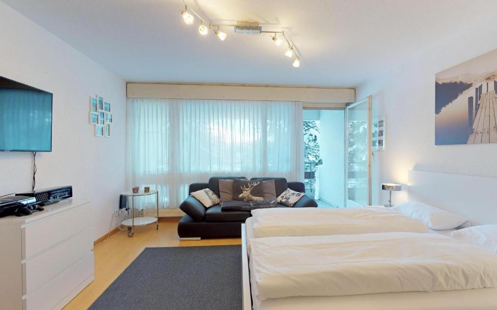 ein Schlafzimmer mit einem Bett und einem Sofa in der Unterkunft Lac 16 in St. Moritz