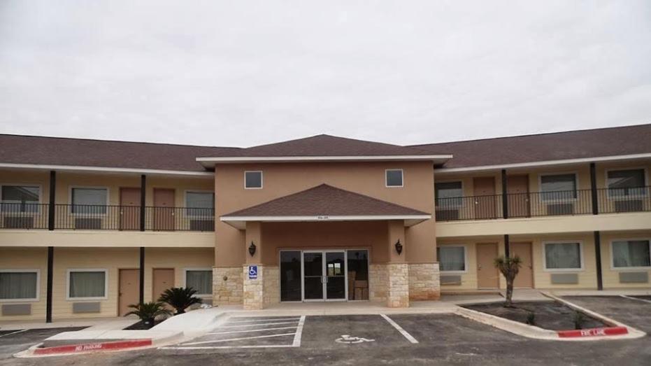 a hotel with a parking lot in front of it at Hotel Cotulla in Cotulla