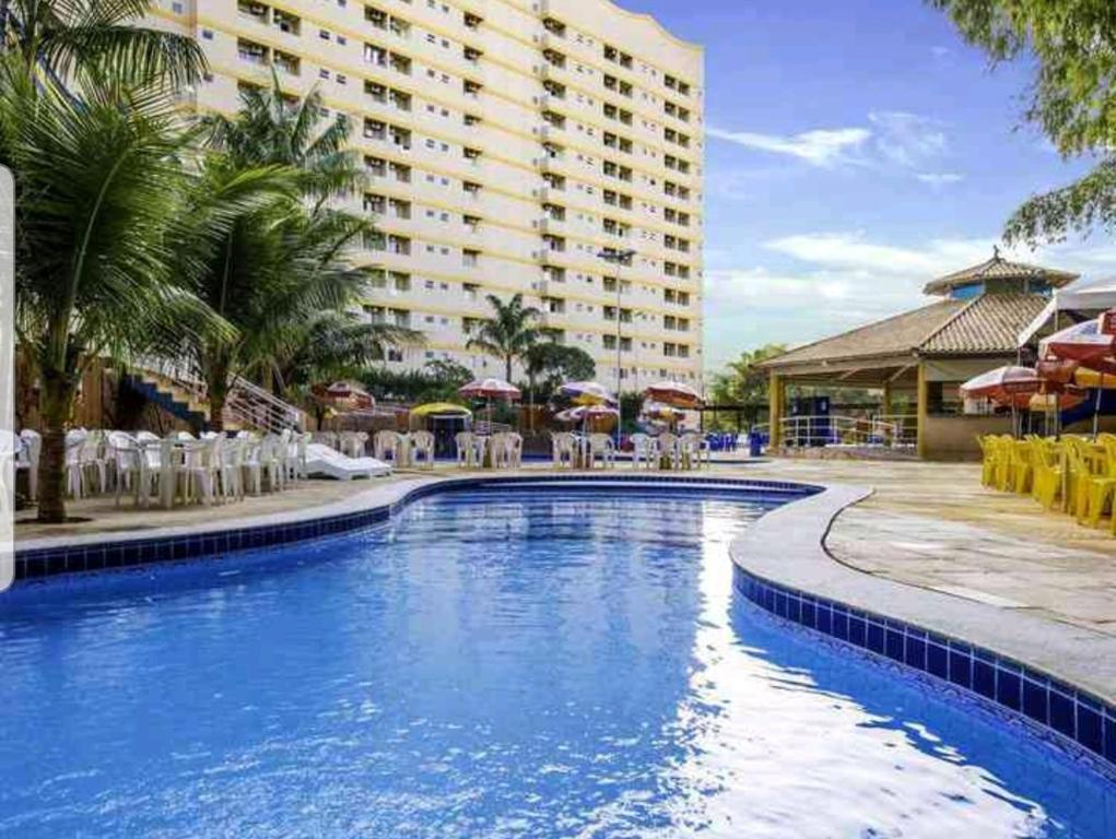 a pool at a resort with chairs and umbrellas at Golden Dolphin Caldas Novas in Caldas Novas