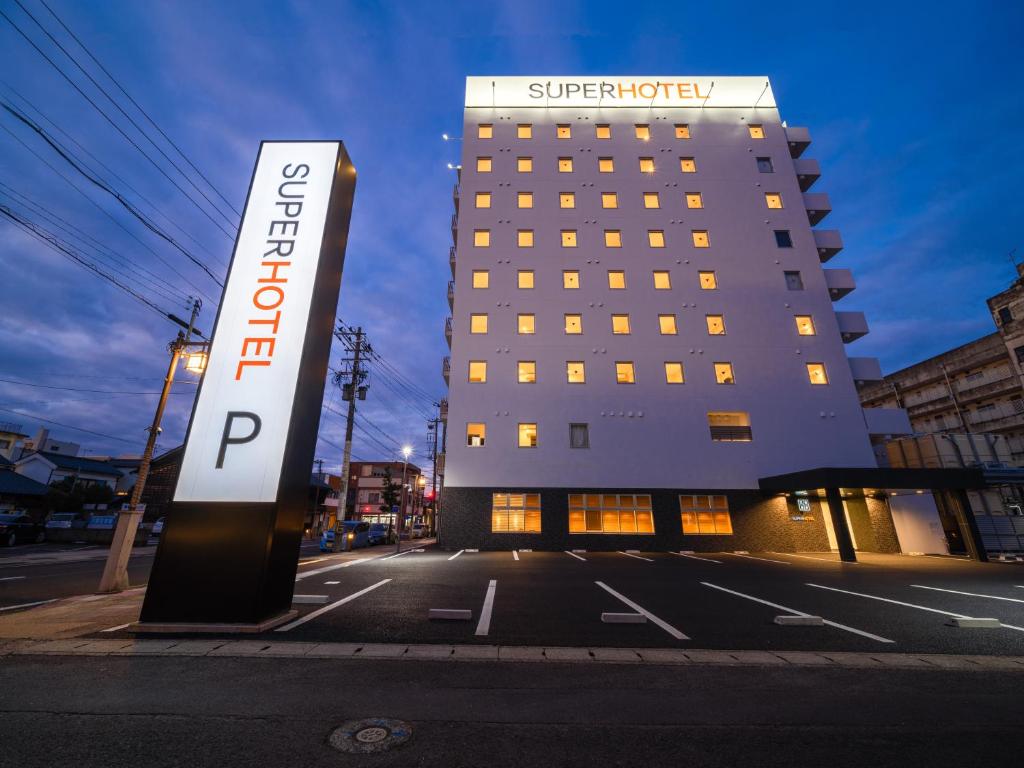 ein Hotelgebäude mit einem Schild davor in der Unterkunft Super Hotel Echizen Takefu in Echizen