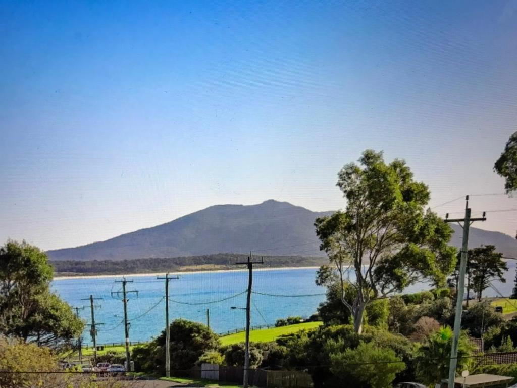 a view of a lake with a mountain in the background at Bermagui Beach Apartment in Bermagui