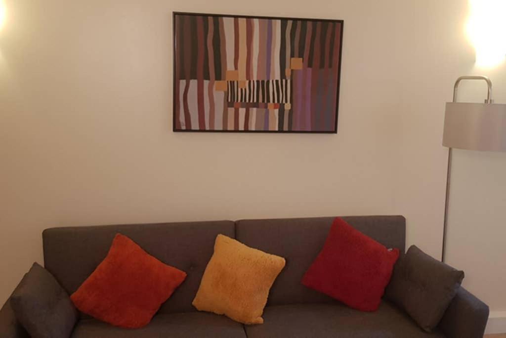 a living room with a couch with four pillows at Garland Modern House With Parking & Garden Croydon in Croydon