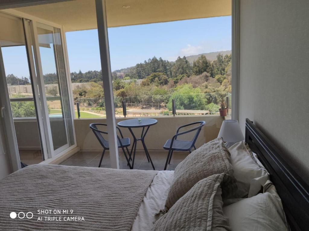 a bedroom with a bed and a table and chairs at Departamento Papudo in Papudo