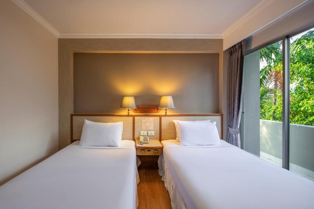 two beds in a room with a desk and windows at Station ONE Hotel - Aranyaprateth in Aranyaprathet