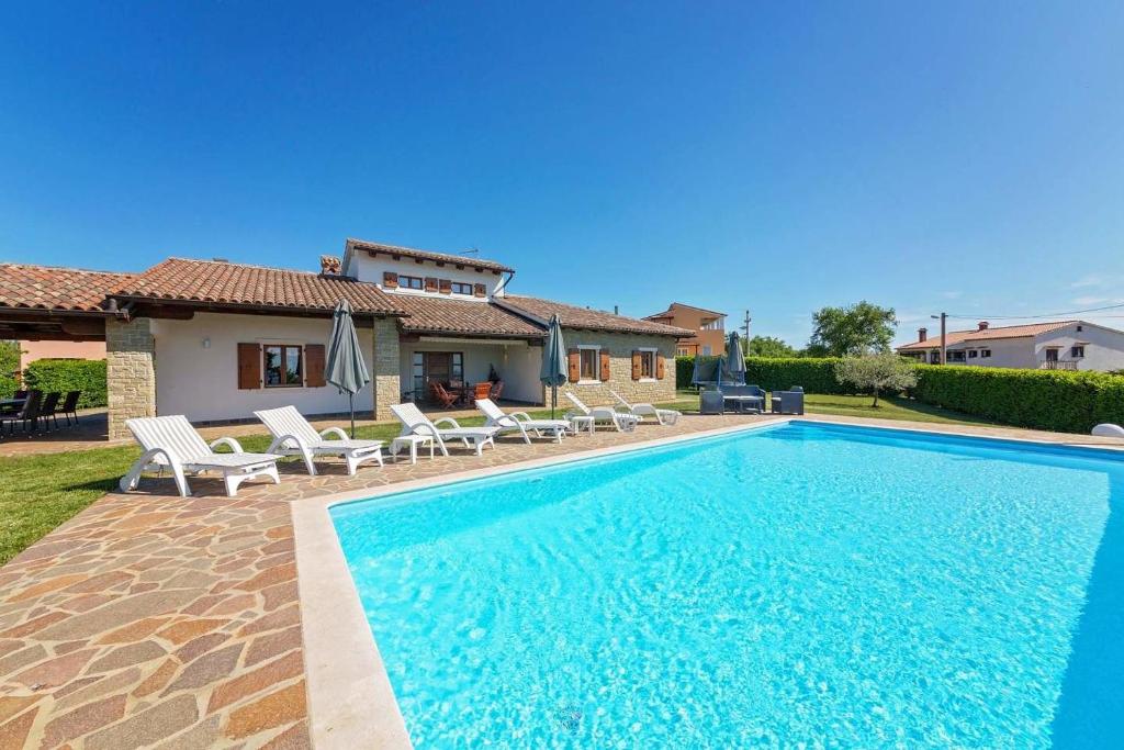 a villa with a swimming pool and a house at Villa Ciano in Višnjan