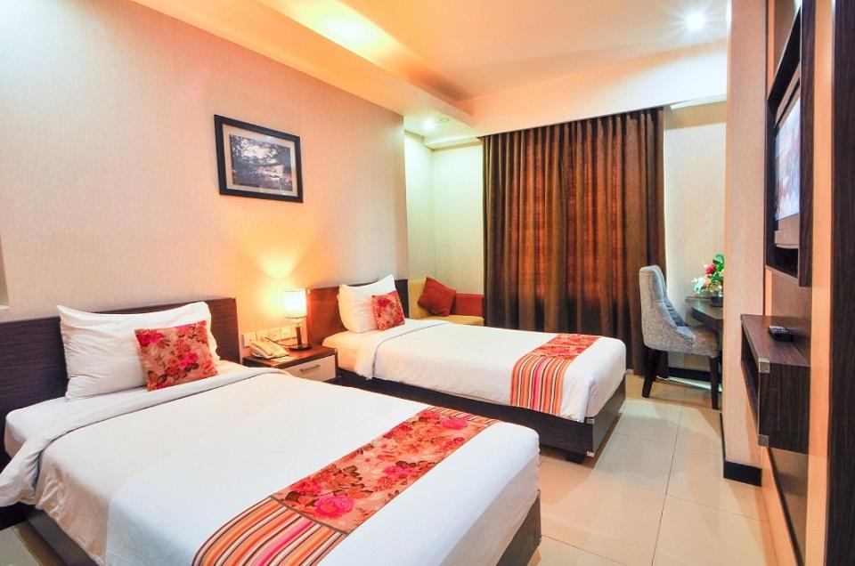 Tempat tidur dalam kamar di Daima Hotel Padang