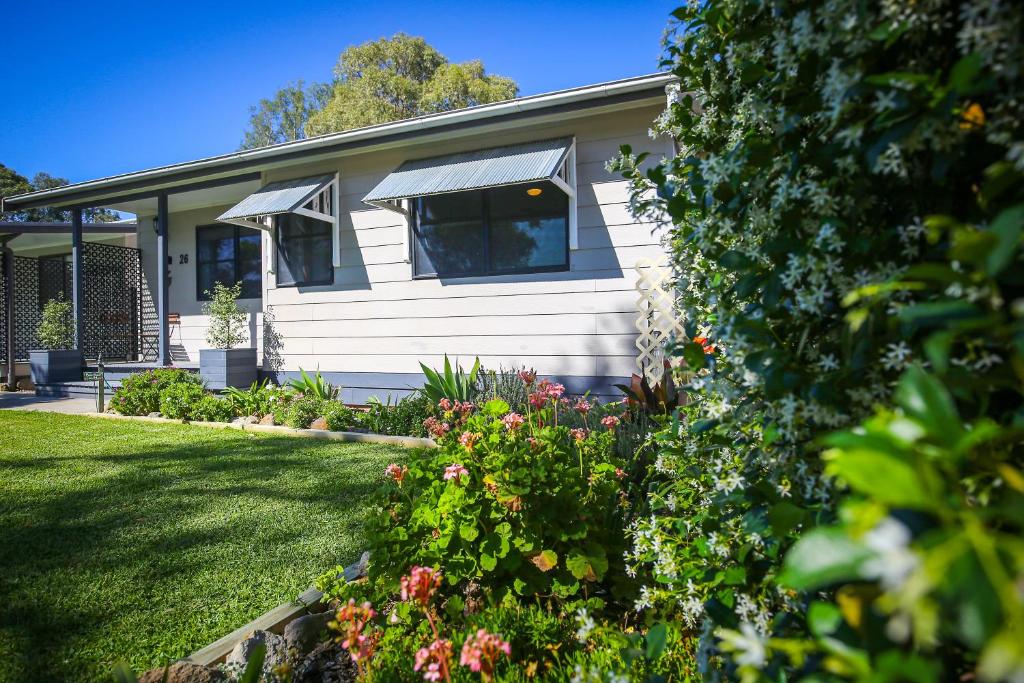 uma casa com um jardim com flores em frente em Dell-Lee Cottage em Broke