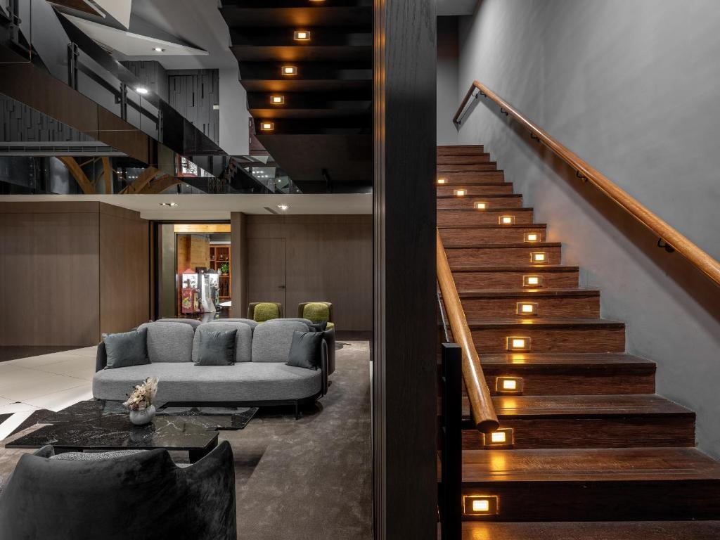 a living room with a couch and a staircase at Kung Shang Design Hotel in Kaohsiung