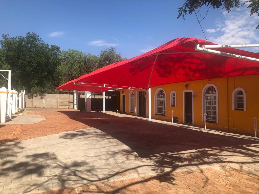 un edificio giallo e rosso con tetto rosso di One More Nap Self Catering a Bloemfontein