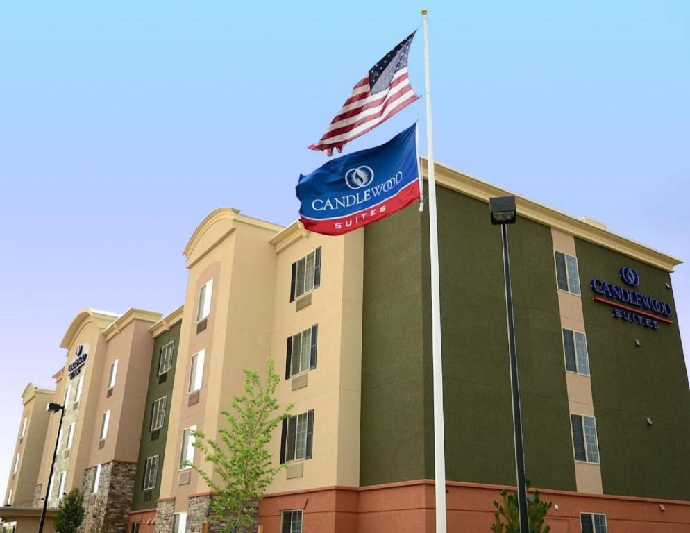 una bandera ondeando frente a un edificio en Candlewood Suites Denver Northeast - Brighton, an IHG Hotel, en Brighton