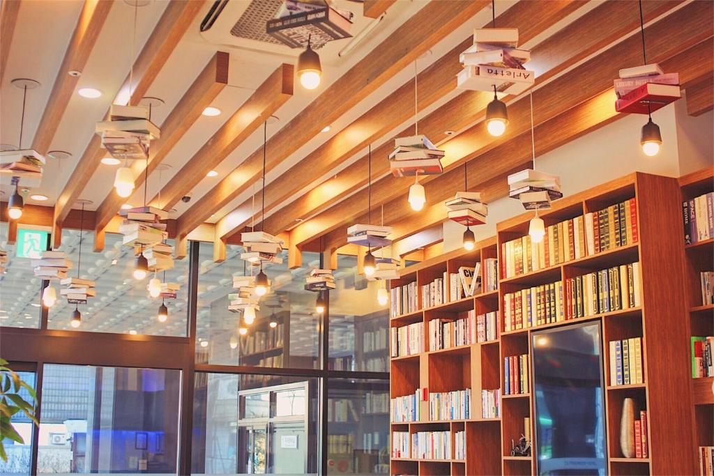 a library with rows of bookshelves and lights at CS Premier Hotel in Anyang