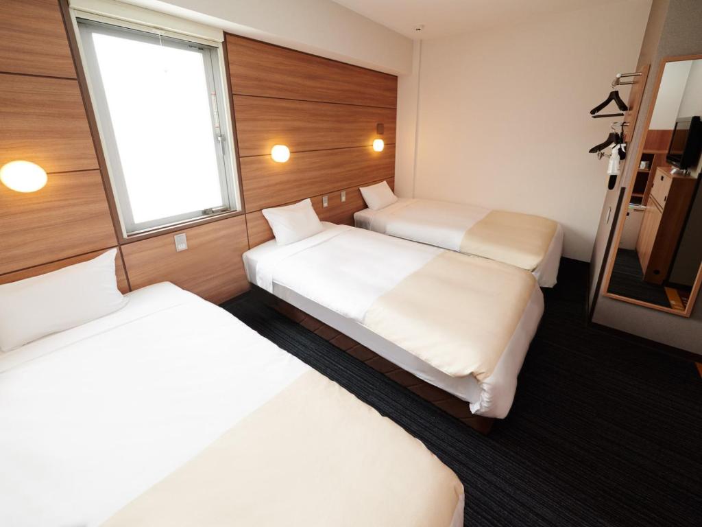 Postel nebo postele na pokoji v ubytování Super Hotel Namba Nipponbashi