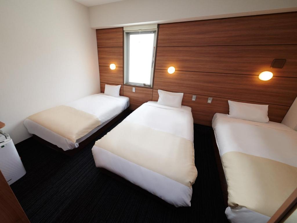 Postel nebo postele na pokoji v ubytování Super Hotel Namba Nipponbashi