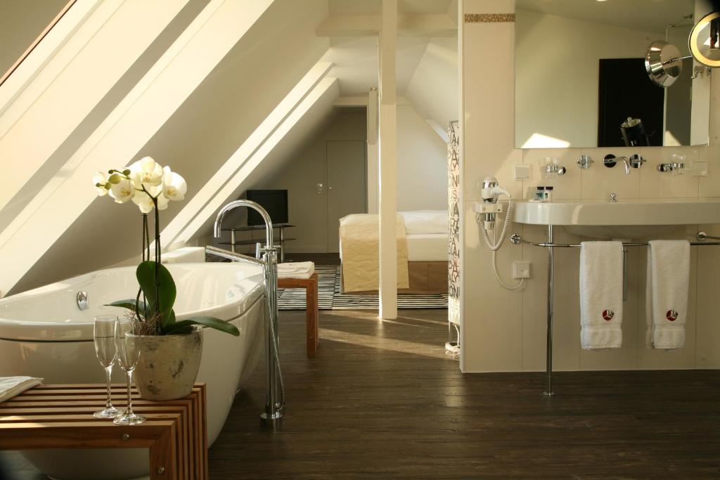 ein Badezimmer mit einer Badewanne und einem Waschbecken in der Unterkunft Apart Hotel Seenelke in Wilhelmshaven