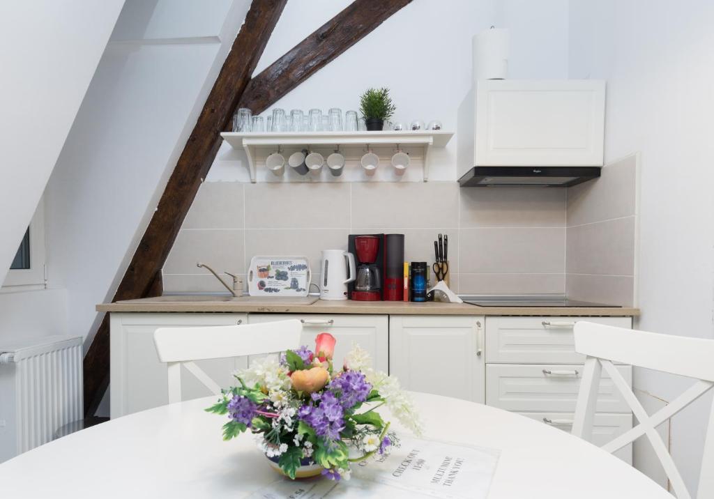 a white kitchen with a table with a vase of flowers at House 54 in Braşov