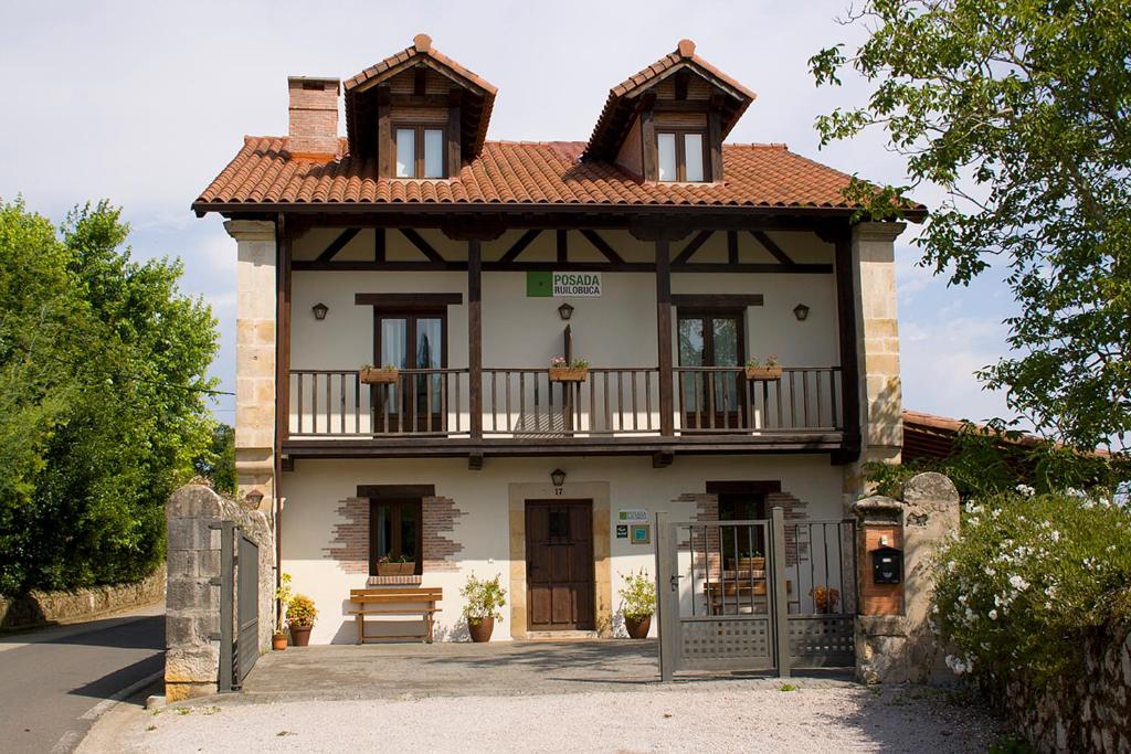 una pequeña casa con balcón en la parte superior en Posada Ruilobuca, en Ruiloba