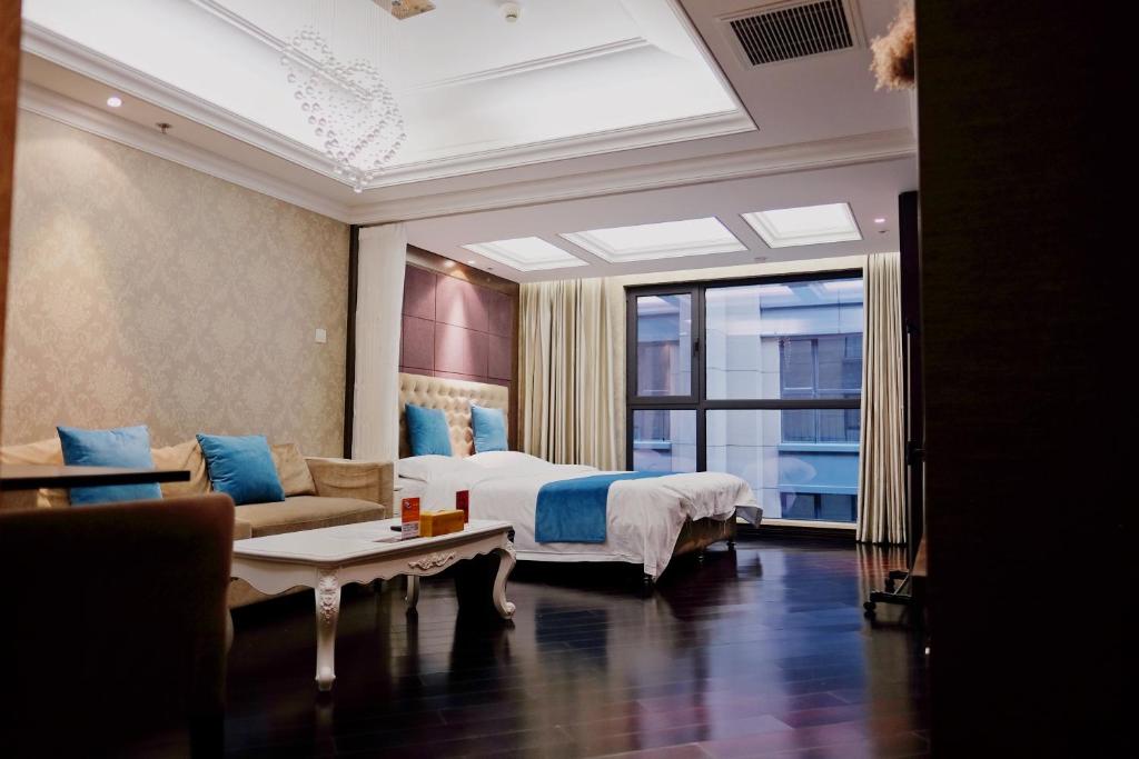 ein Schlafzimmer mit einem Bett, einem Sofa und einem Fenster in der Unterkunft Ring Service Apartment 798 Art Zone in Peking