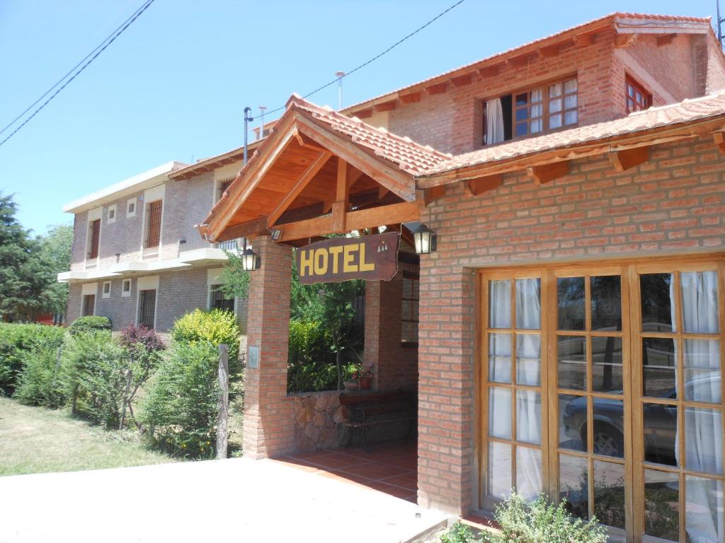 ein Hotelschild vor einem Backsteingebäude in der Unterkunft Principado Sierras Hotel in Mina Clavero