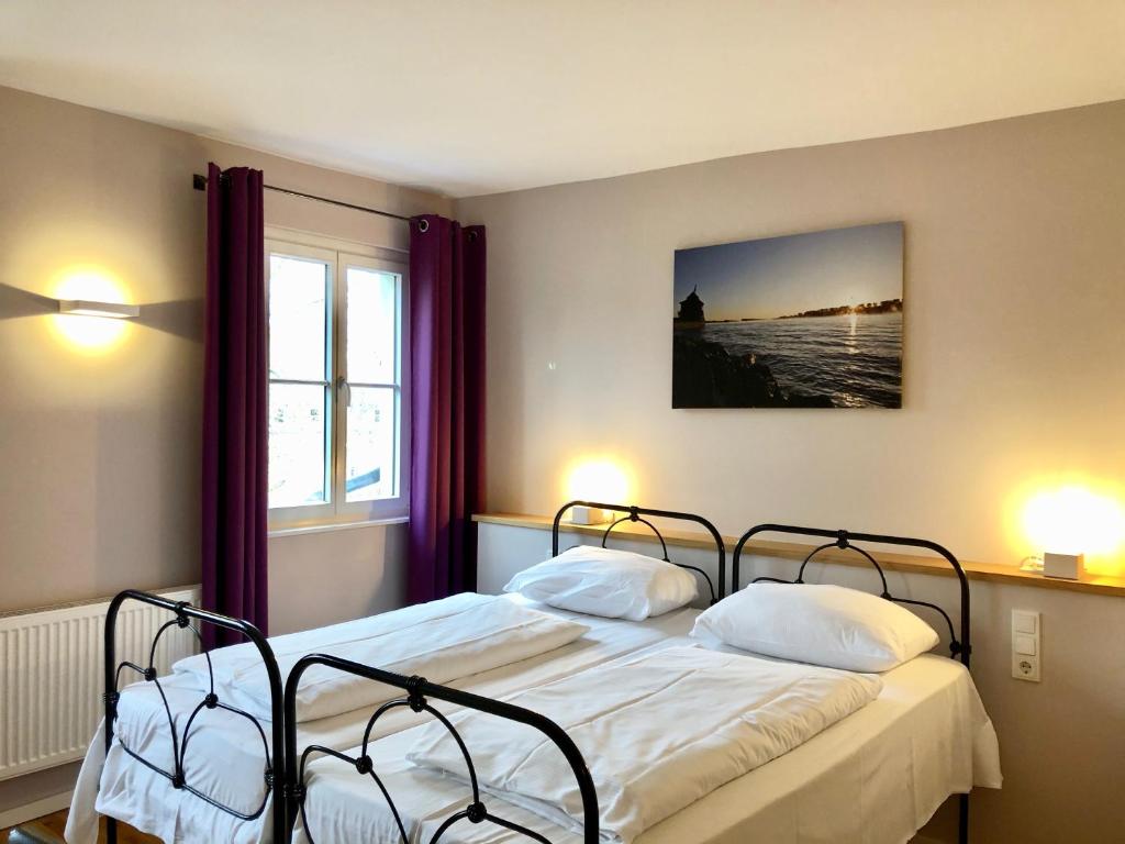 a bedroom with two beds and a window at Hotel Alexander in Wiesbaden