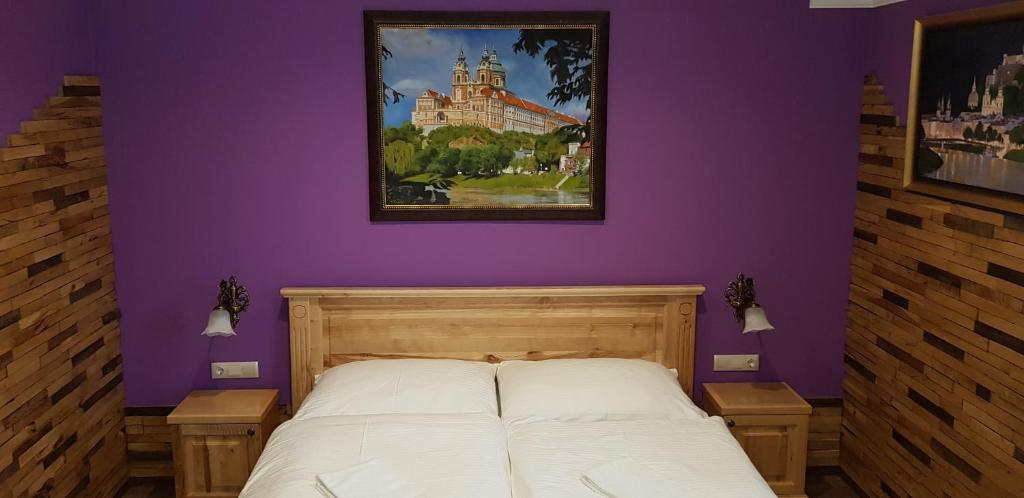 a bedroom with a bed with a painting on the wall at Gasthof Kaiser in Ybbs an der Donau