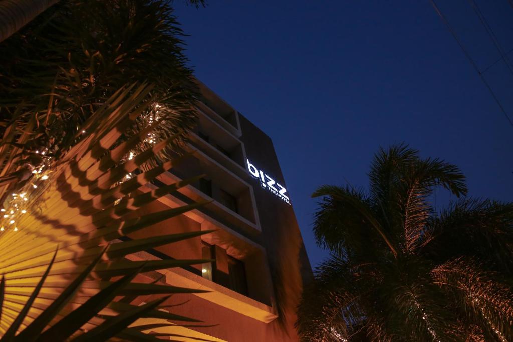 un edificio con un cartel de neón en él por la noche en Bizz The Hotel, en Rajkot