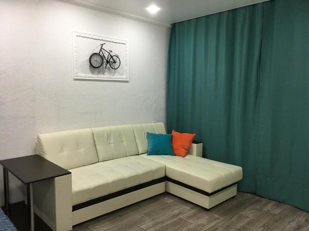 サラトフにあるДороти - уютная квартира на Степана Разинаのリビングルーム(ソファ付)、壁に自転車が備わります。