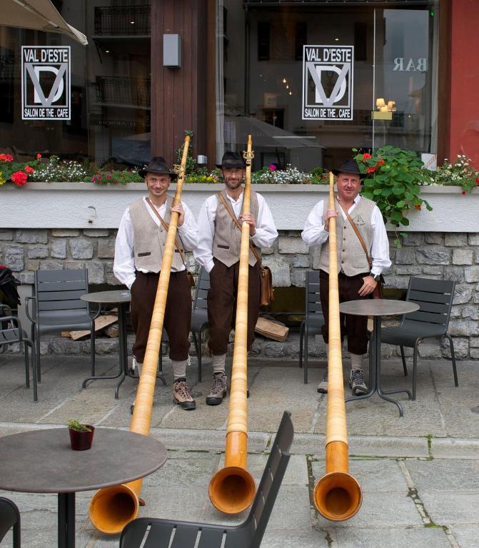 a group of three men holding bamboo musical instruments at Hôtel Val d'Este in Saint-Gervais-les-Bains