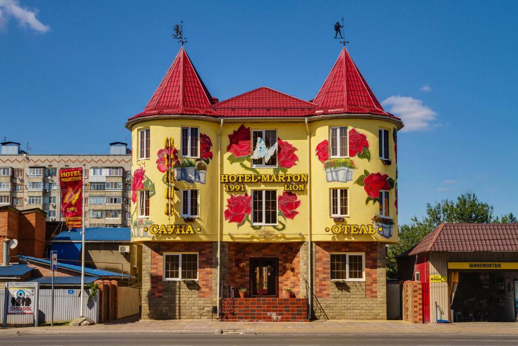 un edificio amarillo con techo rojo en Marton Lion Krasnodar, en Krasnodar