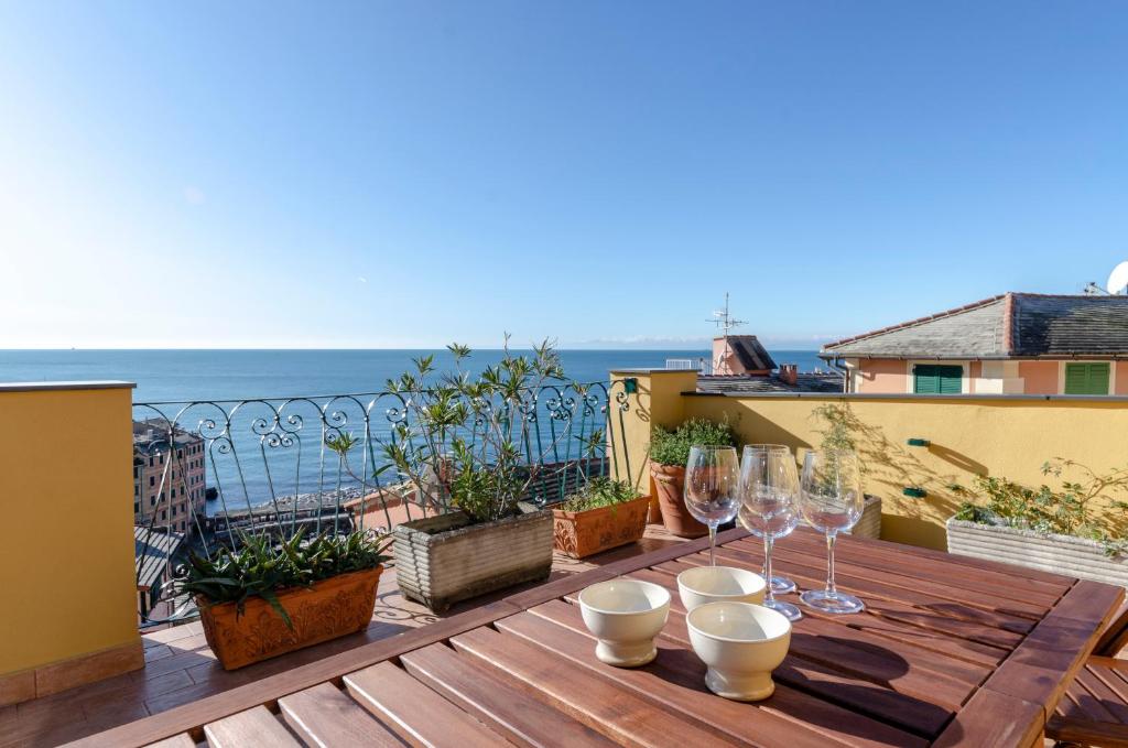 - une table en bois avec des verres à vin sur le balcon dans l'établissement ALTIDO Camogli Treasure for 4 with Terrace and Incredible View, à Camogli