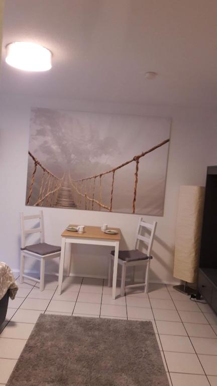 une chambre avec une table, deux chaises et un pont dans l'établissement Zimmer Frei 2, à Wiesbaden
