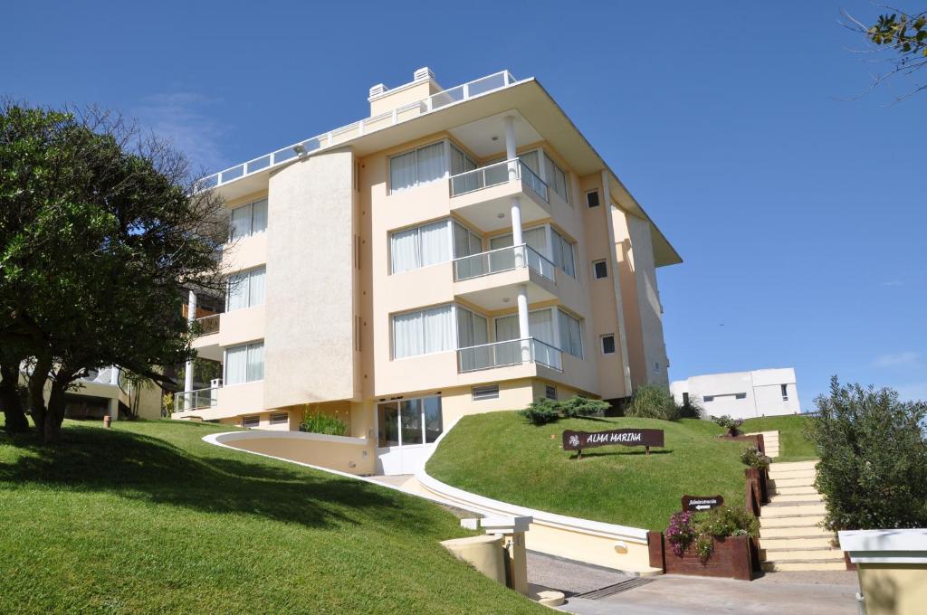 an apartment building with a grassy hill in front of it at Alma Marina in Valeria del Mar
