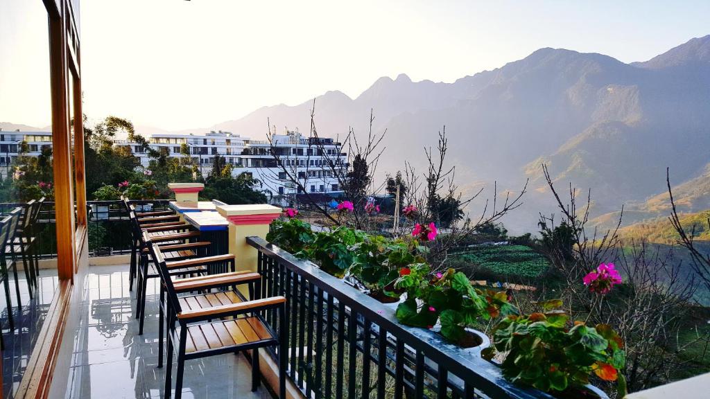 a balcony with chairs and flowers and a view of a mountain at Muong Hoa View Hotel in Sa Pa