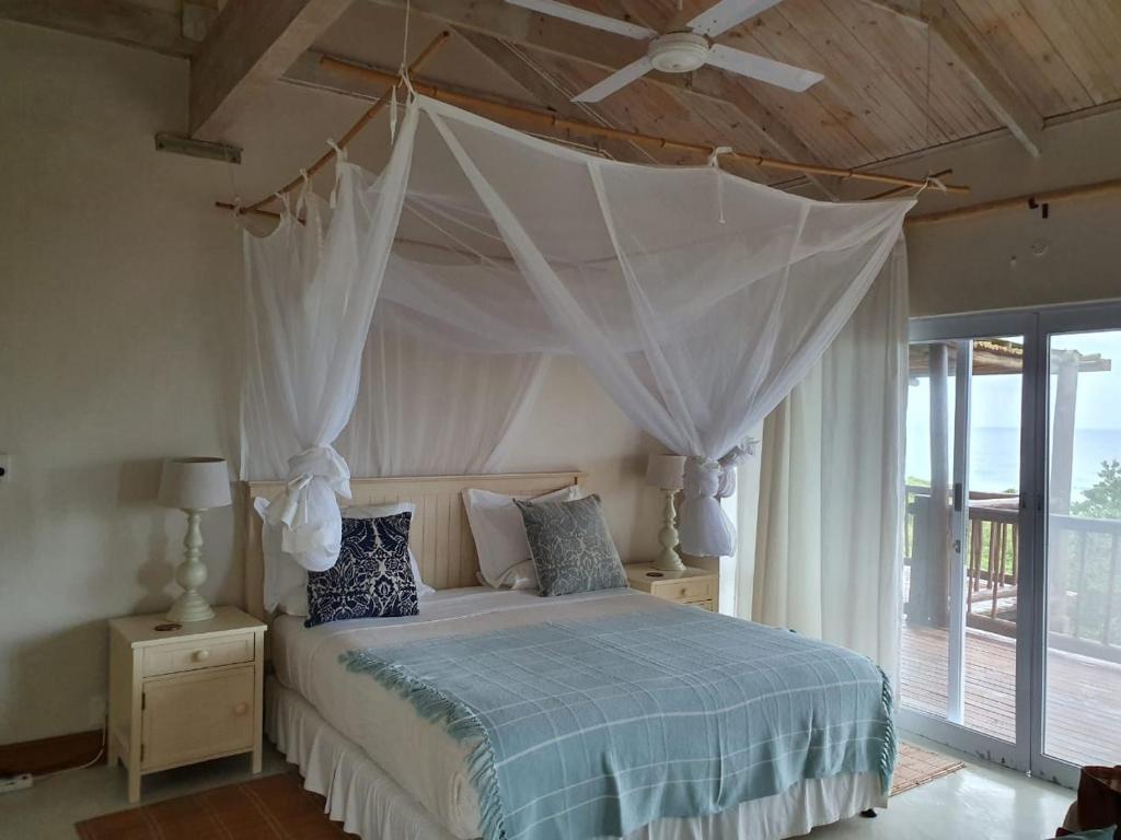 a bedroom with a bed with a canopy at Kangela 11 in Ponta Malongane