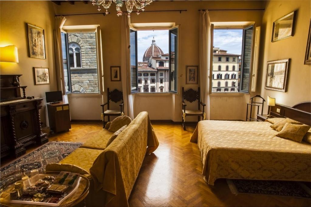 Habitación de hotel con 2 camas y ventanas grandes. en Soggiorno Antica Torre, en Florencia