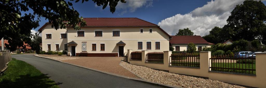 a large white house with a fence in front of it at Pension U Lípy in Rovečné