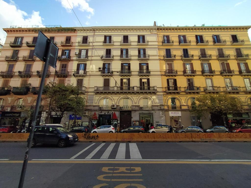 un grand bâtiment jaune avec des voitures garées devant lui dans l'établissement La Casa di Halley, à Naples