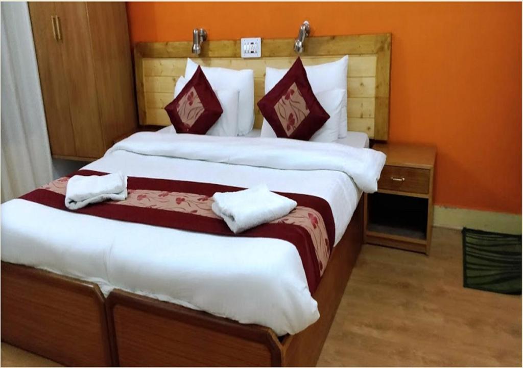 2 Betten in einem Zimmer mit orangefarbenen Wänden in der Unterkunft Royal Heritage Resort in Leh