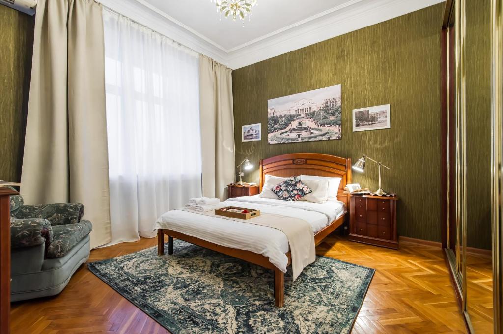 モスクワにあるGMApartments White Houseのベッドルーム1室(ベッド1台、椅子、窓付)